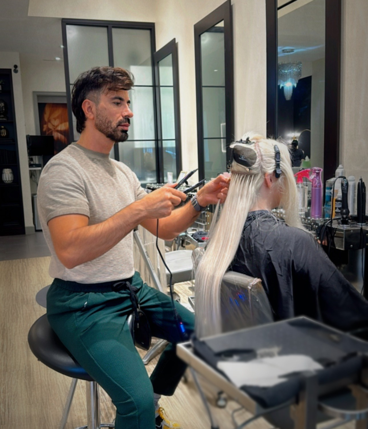 Tony Odisho applying hair extensions on a client at exsalonce